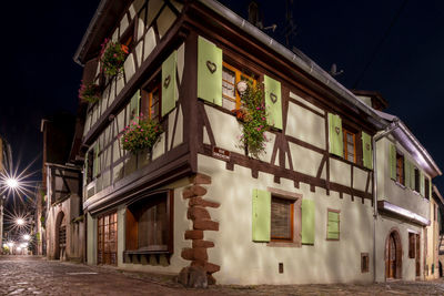 Low angle view of illuminated building against sky at night