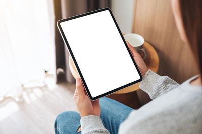 Midsection of woman using digital tablet