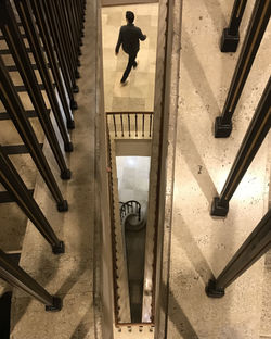 High angle view of man walking on staircase in building