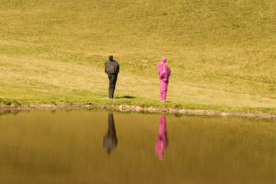 Rear view of two women walking in water