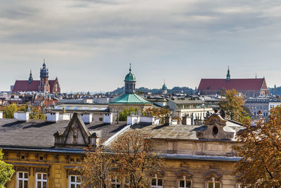 Buildings in city against cloudy sky