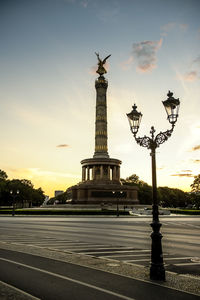 Statue in city against cloudy sky