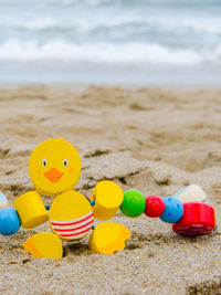 Close-up of toys on beach against sky