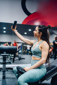 Side view of young woman exercising in gym