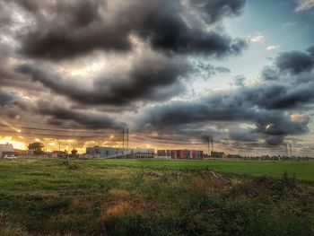 Scenic view of grassy field against cloudy sky