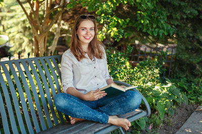 Portrait of smiling young woman sitting outdoors