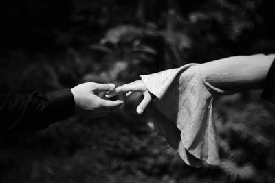 Cropped image of couple holding hands outdoors