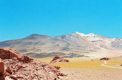 Scenic view of desert against clear blue sky