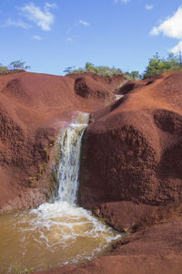 Scenic view of waterfall against sky