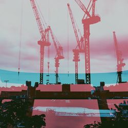 Cranes at construction site against sky