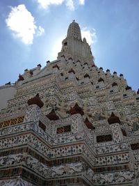 Low angle view of buddha statue against cloudy sky