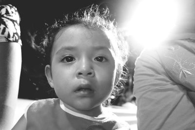 Close-up portrait of toddler against illuminated street light