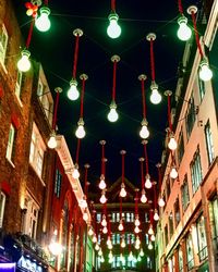 Low angle view of illuminated lanterns hanging by building