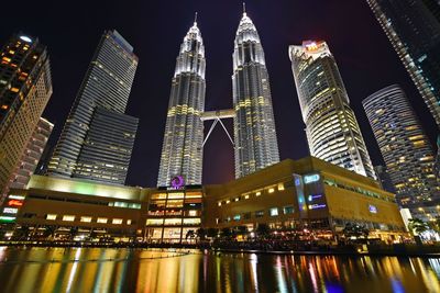 Low angle view of illuminated buildings against sky at night