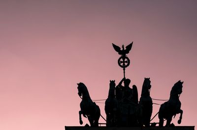 Silhouette statue against sky during sunset