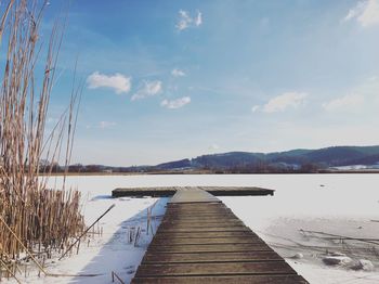 Pier over lake against sky