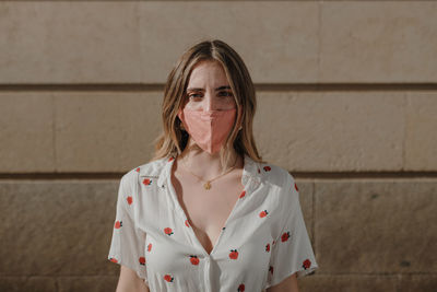 Portrait of woman standing against wall