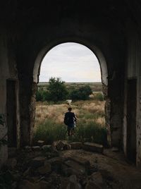 Rear view of man walking in tunnel