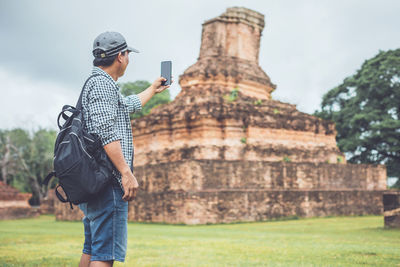 Asian tourist working and using laptop at sukhothai historical park, thailand. 