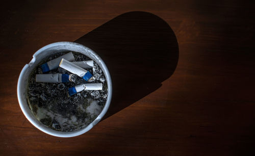 High angle view of cigarette butts in ashtray on table