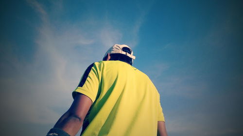 Low angle view of man against blue sky