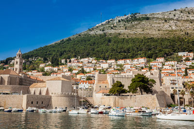 Aerial view of townscape by sea against sky