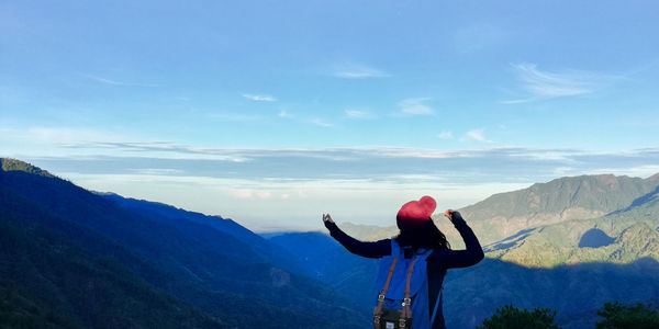 Man standing on mountain against sky