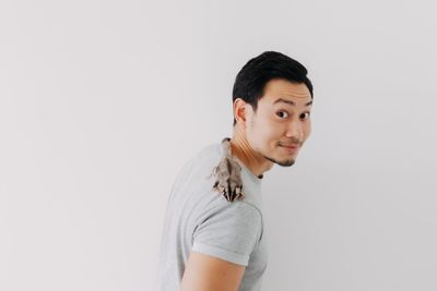 Portrait of young woman standing against white background