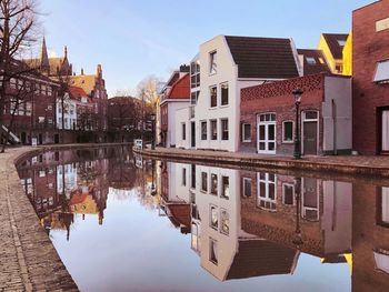 Canal amidst buildings in town against sky