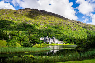 Scenic view of lake by buildings against sky