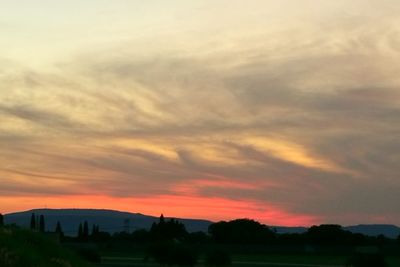Scenic view of dramatic sky over silhouette landscape