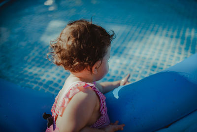 Side view of baby girl by wading pool