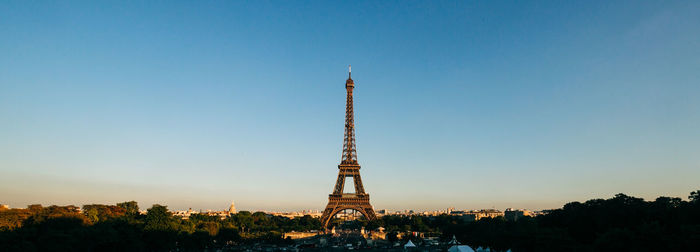 Communications tower in city against sky