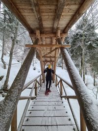 Rear view of people on bridge during winter