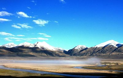 Scenic view of mountains against blue sky