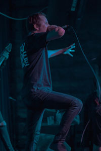 Full length of young man standing at music concert