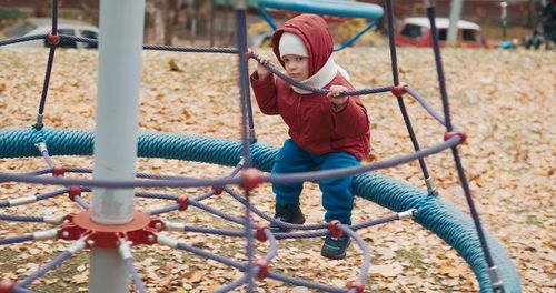 Rear view of boy playing in playground