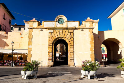 Potted plants outside historic building against sky