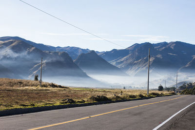 Road by mountains against sky