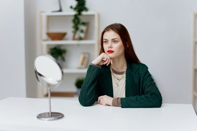 Portrait of young woman drinking coffee at home