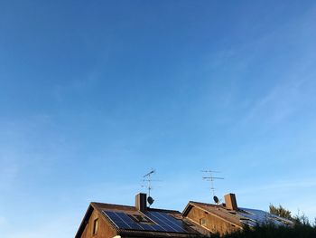 High section of houses with antenna against blue sky