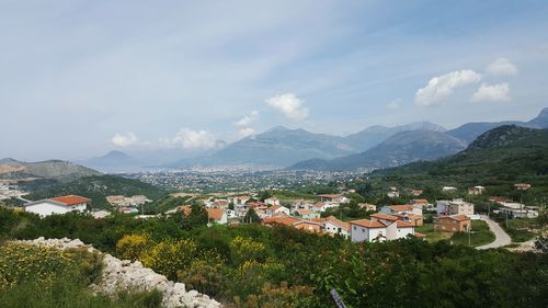 Residential district by mountains against sky