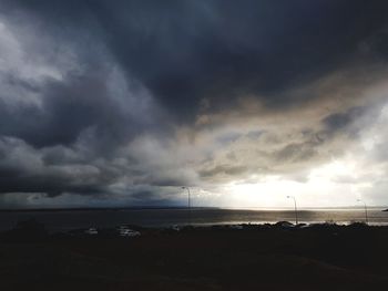 Scenic view of beach against dramatic sky