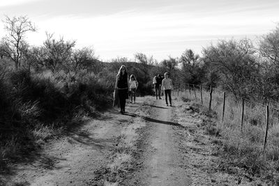 Rear view of people walking on footpath