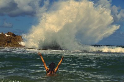 Man splashing water against sky