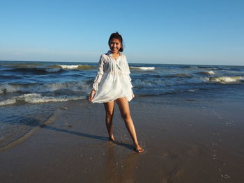 Full length portrait of woman standing on beach