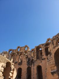 Low angle view of old ruins against blue sky