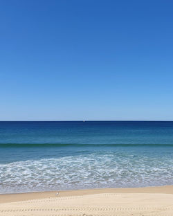 Scenic view of sea against clear blue sky