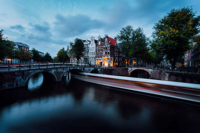 Bridge over river in city against sky