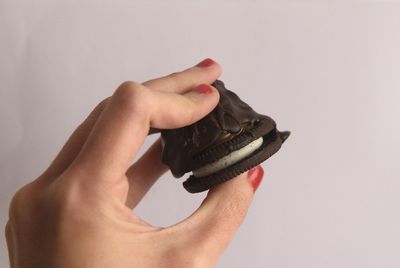 Close-up of man holding hands over white background